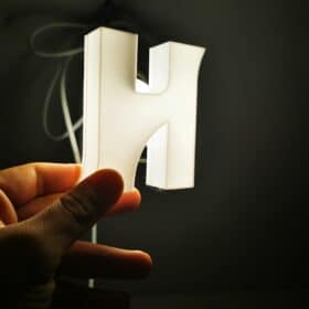 Trójwymiarowa litera 'H' świecąca całą powierzchnią z innowacyjnym systemem montażu, pięcioletnia gwarancja, dostępna w ultra małych, małych i średnich rozmiarach